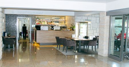 Außenansicht des gelben Gebäudes des Hotels San Simon Dependance, umgeben von Bäumen und Sträuchern.