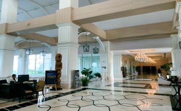 Weitläufige Empfangshalle des Titanic Deluxe Hotels mit stilvollen Sitzbereichen und hochwertigem Design.