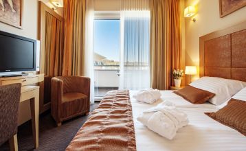 Frontansicht des Grand Hotel Primus Terme Ptuj mit gepflegtem Rasen und Blumen.