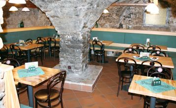 Der Empfangsbereich des Hotels Koruna, mit einer hölzernen Rezeption und einer roten Teppichtreppe, die nach oben führt.