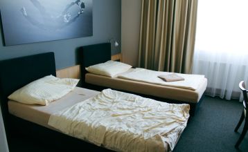 Außenansicht des Hotels OtavArena mit moderner Fassade und Sonnenterrasse.