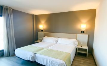 Außenansicht des Gran Hotel Verdi mit moderner Glasfassade und urbaner Umgebung.