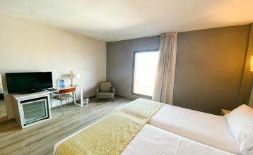 Außenansicht des Gran Hotel Verdi mit moderner Glasfassade und urbaner Umgebung.