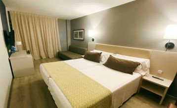 Außenansicht des Gran Hotel Verdi mit moderner Glasfassade und urbaner Umgebung.