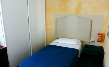 Außenansicht des Hotels Villa Maria mit Balkonen, gepflegtem Garten und mehreren Nationalflaggen vor dem Gebäude