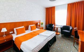 Luftbildaufnahme einer Hotelanlage mit Tennisplätzen, Pool und Parkflächen.